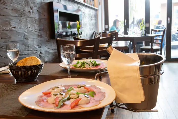 Vorspeisenteller mit Brot und Salat auf dem gedeckten Tisch