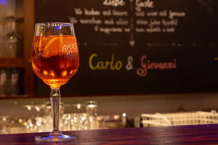 Aperitif im Weinglas vor der Kreidetafel mit den Namen Carlo und Giovanni