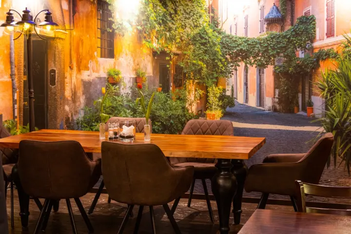 Tisch vor dem Wandbild einer italienischen Gasse